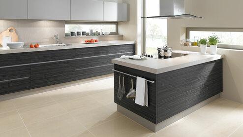Impression einer Küchengestaltung mit Kochinsel Impression einer Küchengestaltung mit Kochinsel mit Edelstahlabzug und dunklen Fronten