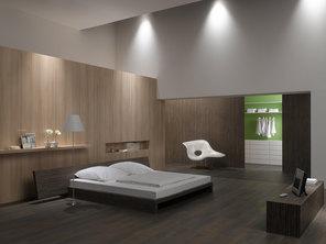 Schlafzimmerimpression mit Holzverkleidung an Wand Schlafzimmerimpression von Bett, Nachtisch und Sideboard mit Holzverkleidung an Wand und indirektert Beleuchtung