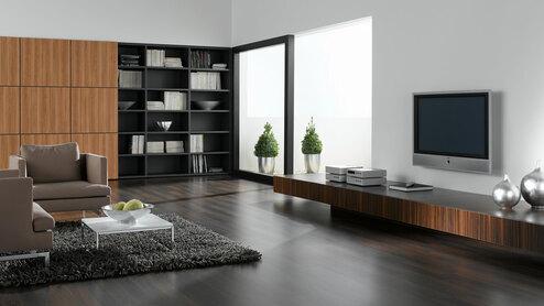 Wohnraumimpression mit dunklem Mobiliar Wohnraumimpression mit verschieden dunklen Holzoberflächen für Einbauschrank, Sideboard und Bodenbelag